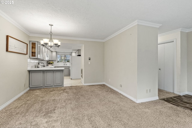 interior space featuring light carpet, an inviting chandelier, a textured ceiling, and ornamental molding