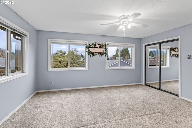 unfurnished bedroom with ceiling fan, carpet flooring, a textured ceiling, and a closet