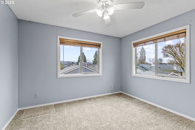 empty room with a healthy amount of sunlight, ceiling fan, and carpet floors