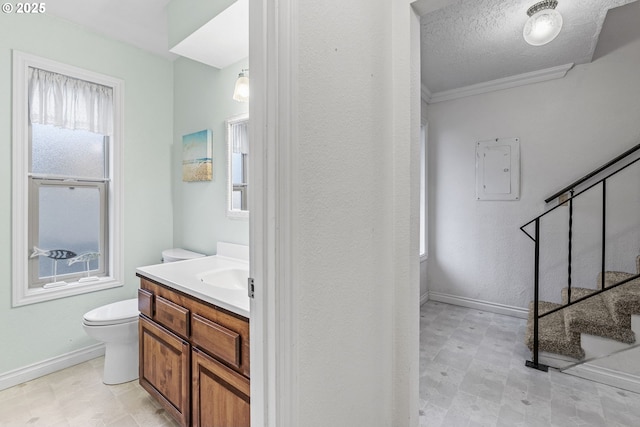 bathroom with toilet, a textured ceiling, electric panel, crown molding, and vanity