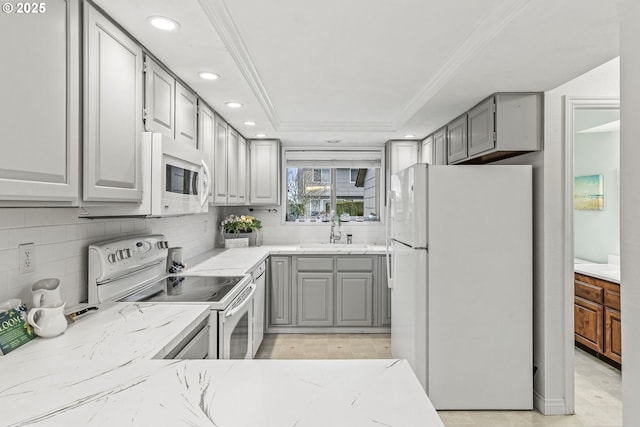 kitchen featuring sink, white appliances, crown molding, and gray cabinetry