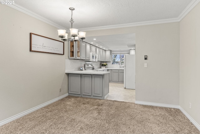 kitchen with kitchen peninsula, white appliances, crown molding, and light colored carpet