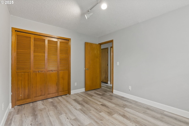 434 SW Eastman Pkwy, Gresham, OR 97080 - unfurnished bedroom featuring light wood finished floors, a closet, baseboards, and a textured ceiling