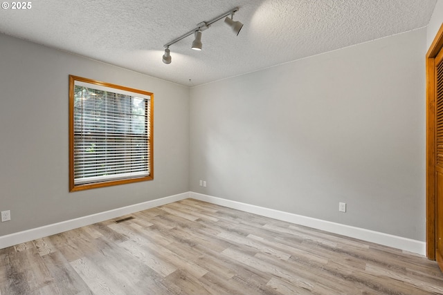 434 SW Eastman Pkwy, Gresham, OR 97080 - spare room featuring a textured ceiling, light wood-style floors, track lighting, and baseboards