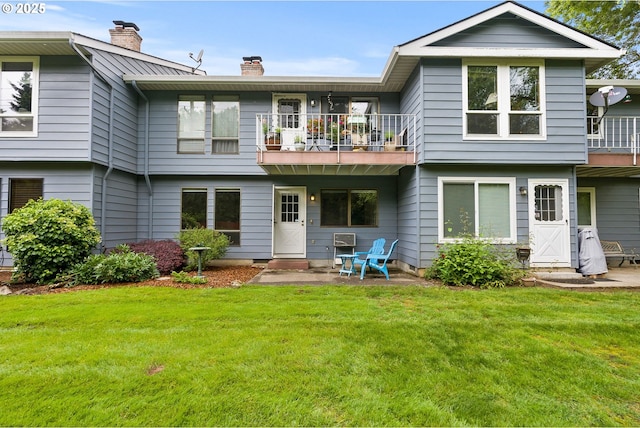 434 SW Eastman Pkwy, Gresham, OR 97080 - rear view of house featuring a balcony, a chimney, and a lawn
