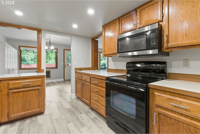 434 SW Eastman Pkwy, Gresham, OR 97080 - kitchen featuring electric range, stainless steel microwave, light countertops, a chandelier, and brown cabinets