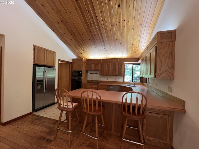 42250 Cedar Hollow Rd, Port Orford, OR 97465 - kitchen featuring black appliances, a peninsula, a sink, light wood-type flooring, and brown cabinets