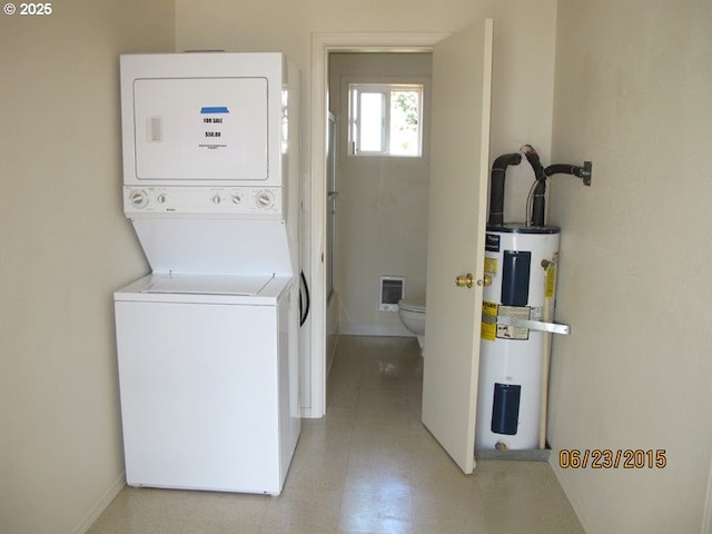 laundry area with laundry area, visible vents, electric water heater, baseboards, and stacked washer / drying machine