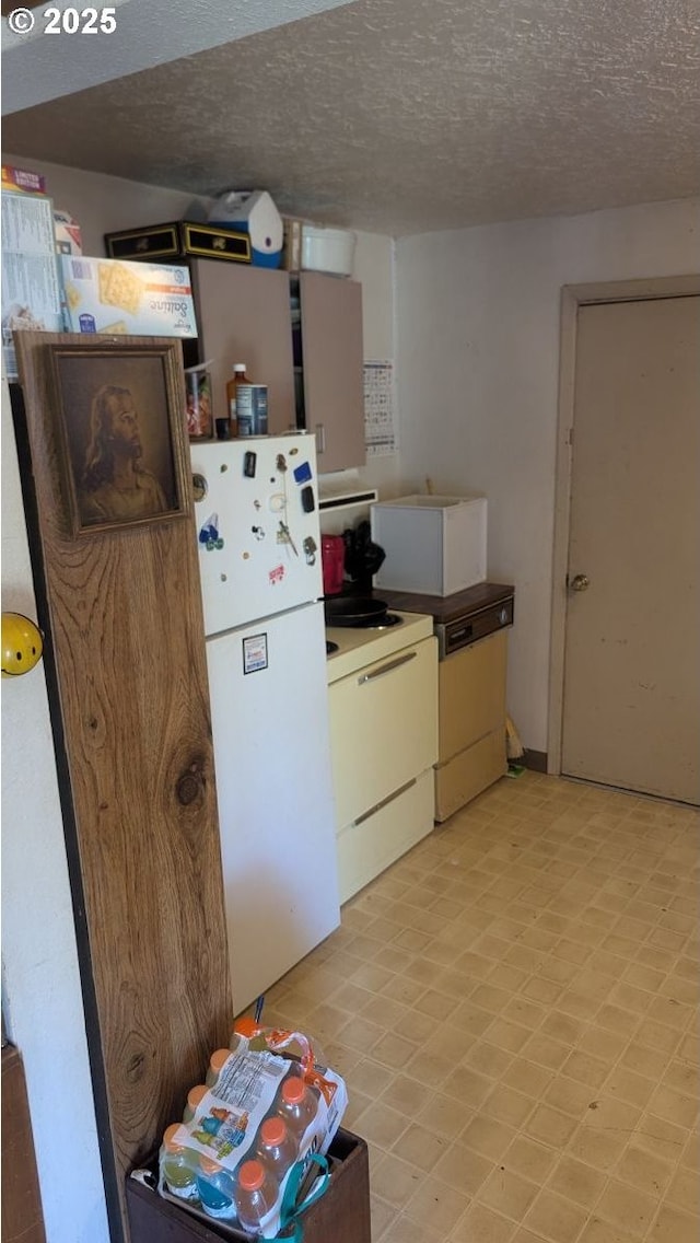 8428 SE 60th Ave, Portland, OR 97206 - kitchen with stove, freestanding refrigerator, a textured ceiling, and light floors