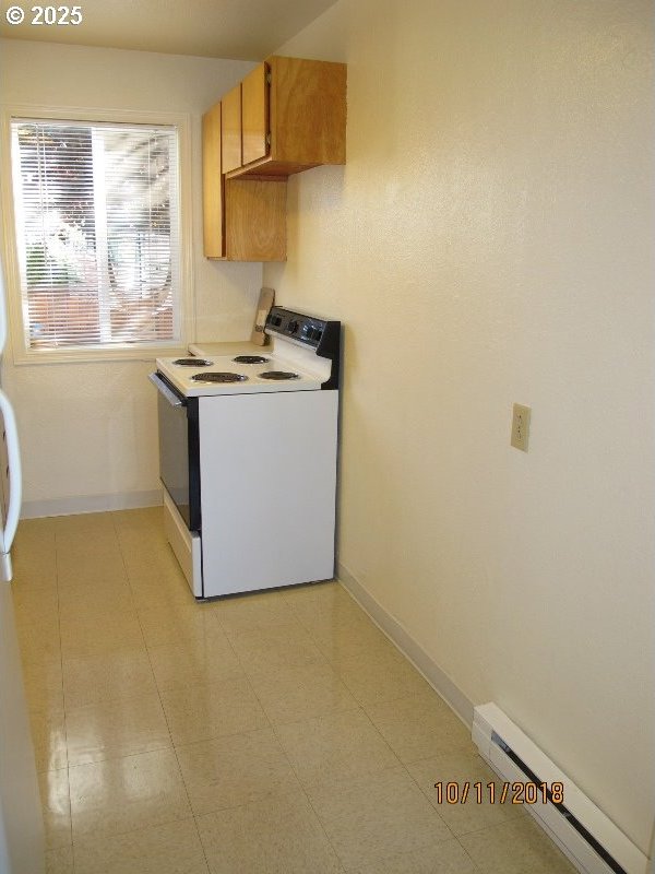 kitchen with white range with electric stovetop, baseboard heating, and baseboards