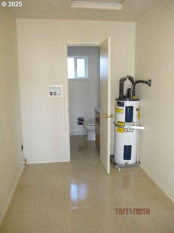 laundry area with water heater, baseboards, laundry area, and washer hookup