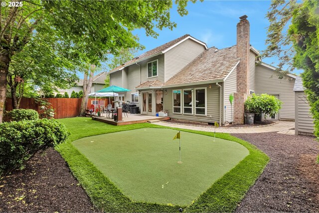 19642 SW 56th Ct, Tualatin, OR 97062 - back of property with a putting area, fence, a chimney, a deck, and a patio area