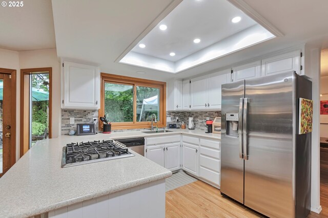 19642 SW 56th Ct, Tualatin, OR 97062 - kitchen featuring stainless steel appliances, a sink, a raised ceiling, recessed lighting, and light countertops