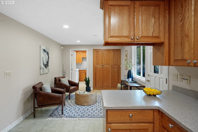 kitchen featuring recessed lighting, baseboards, brown cabinets, light countertops, and light tile patterned flooring