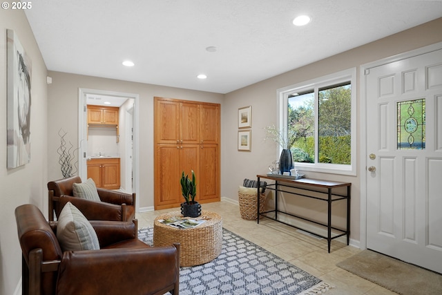 sitting room featuring baseboards, light tile patterned floors, and recessed lighting