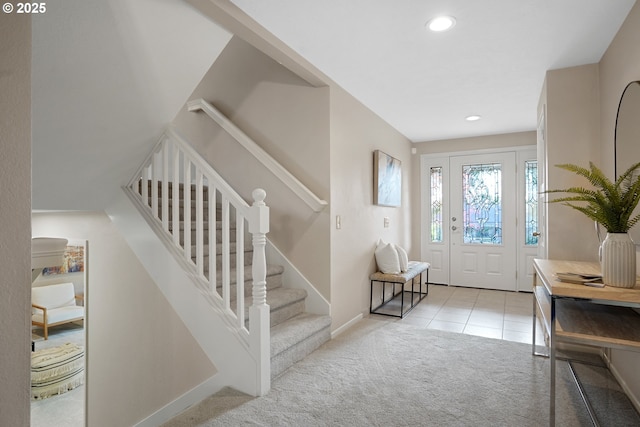 entryway featuring tile patterned flooring, recessed lighting, baseboards, stairs, and carpet