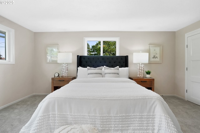 bedroom with baseboards and light colored carpet