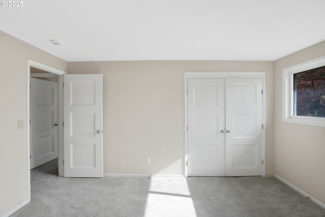 unfurnished bedroom featuring carpet floors, a closet, and baseboards