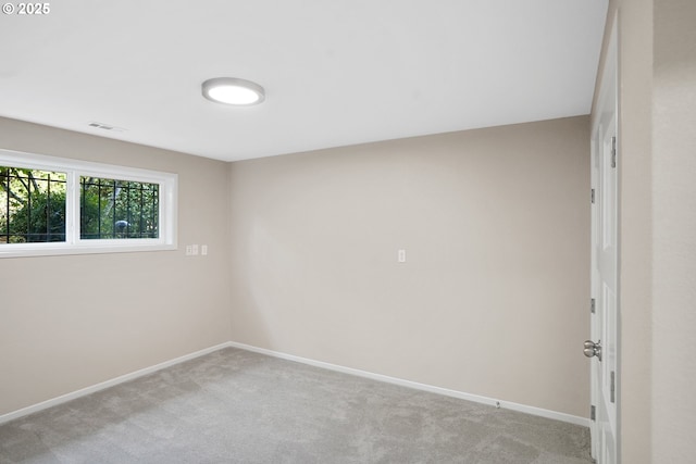 unfurnished room featuring baseboards, visible vents, and light colored carpet