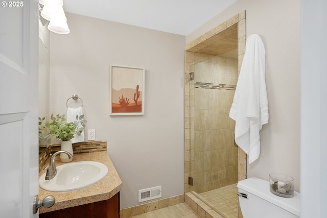 full bathroom featuring toilet, a stall shower, vanity, and visible vents