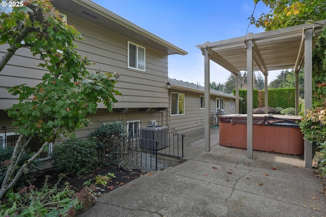 exterior space featuring a patio, a hot tub, and central air condition unit