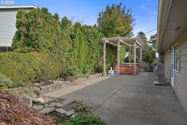 view of patio / terrace featuring a hot tub, fence, and a pergola