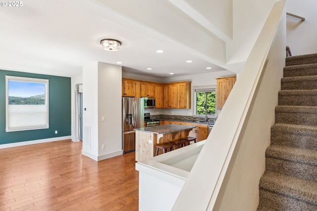 201 Selkirk Ln, Hood River, OR 97031 - kitchen featuring appliances with stainless steel finishes, a center island, light wood-type flooring, baseboards, and dark countertops