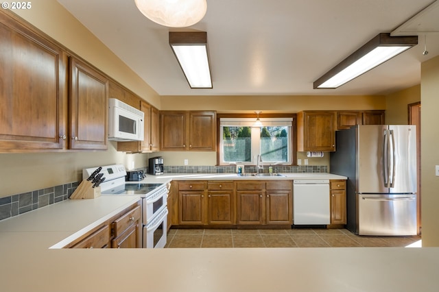 kitchen with white appliances, sink, and light tile patterned floors