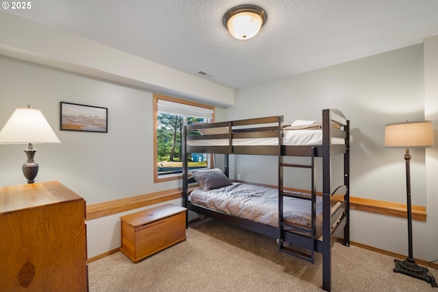 carpeted bedroom featuring a textured ceiling