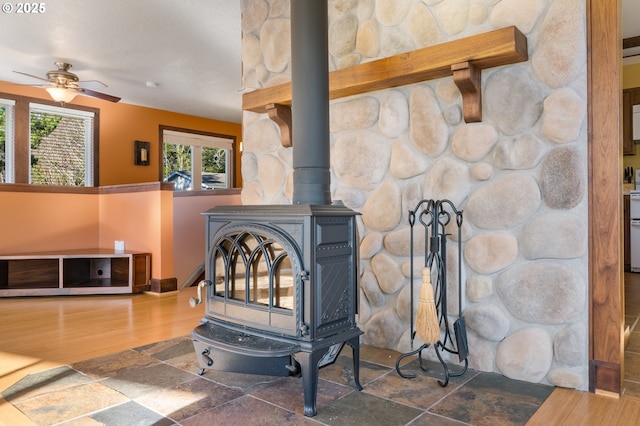 room details featuring a wood stove, hardwood / wood-style floors, and ceiling fan