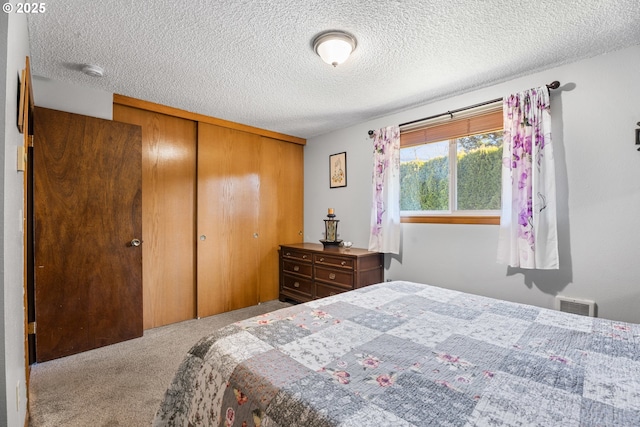 carpeted bedroom with a closet and a textured ceiling