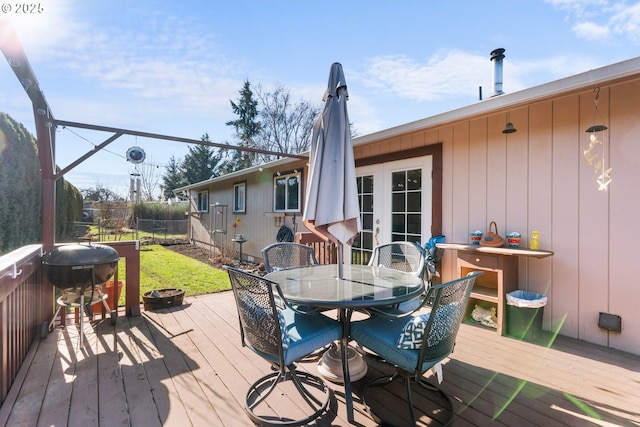 wooden deck featuring grilling area, french doors, and an outdoor fire pit