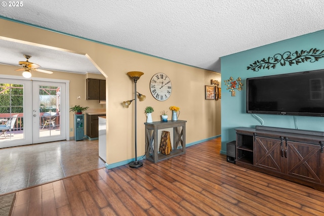 living room featuring ceiling fan, hardwood / wood-style floors, a textured ceiling, and french doors