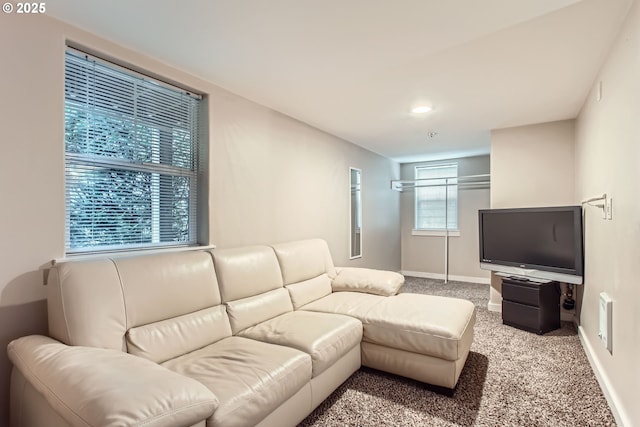 carpeted living area with baseboards