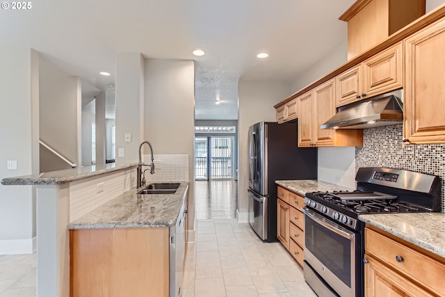kitchen featuring a sink, decorative backsplash, appliances with stainless steel finishes, and under cabinet range hood