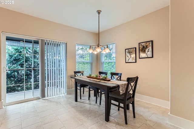 dining space featuring an inviting chandelier, baseboards, and plenty of natural light