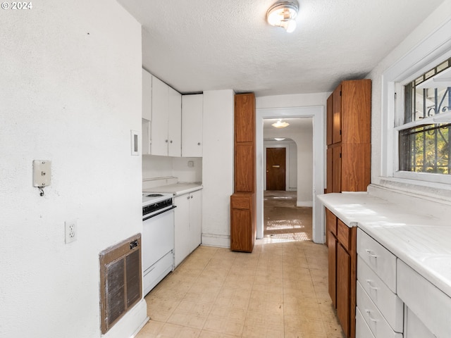 kitchen featuring a textured ceiling, white cabinets, and white electric stove