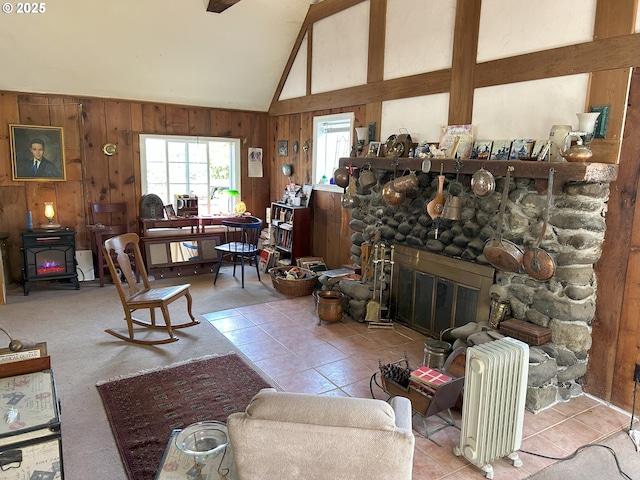 tiled living area with a fireplace, wood walls, a wood stove, radiator, and lofted ceiling