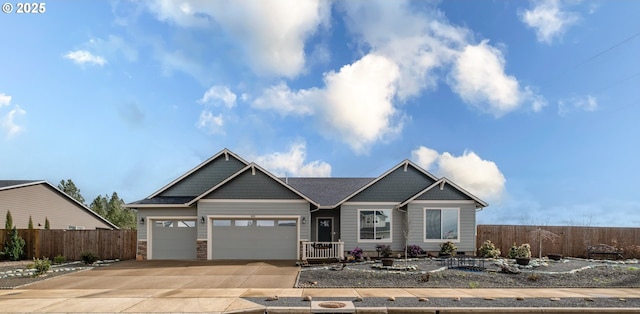 view of front of home featuring a garage, concrete driveway, and fence