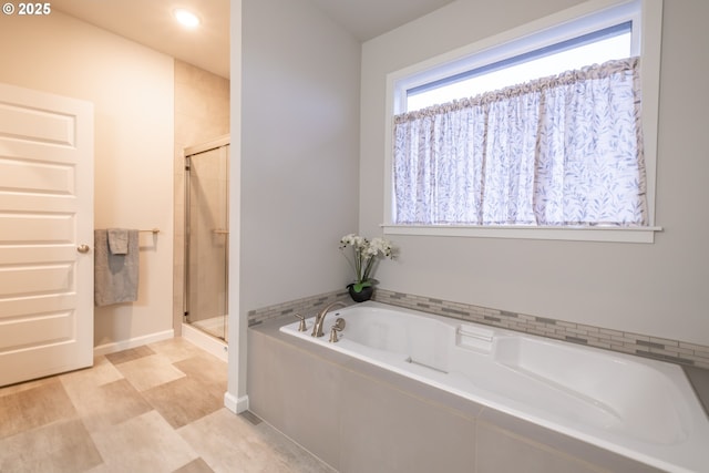 full bath with a shower stall and a garden tub