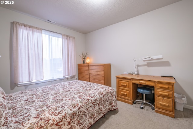 bedroom featuring light colored carpet and a textured ceiling
