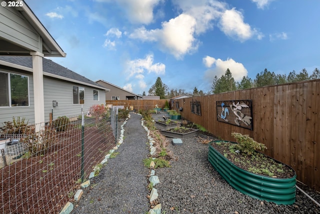 fenced yard featuring a garden