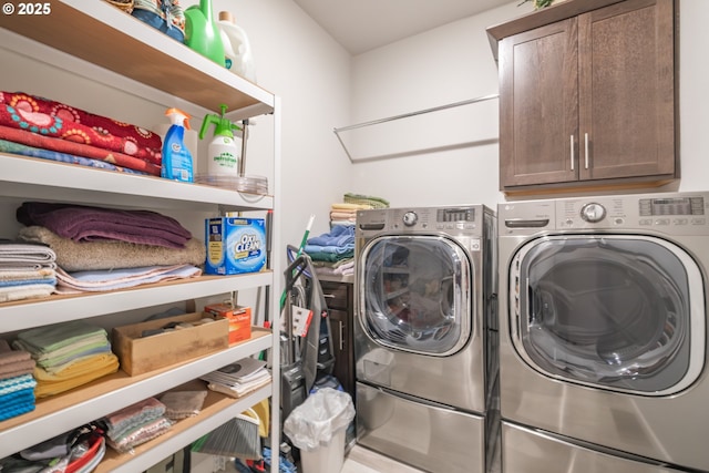 laundry room with washing machine and clothes dryer and cabinet space