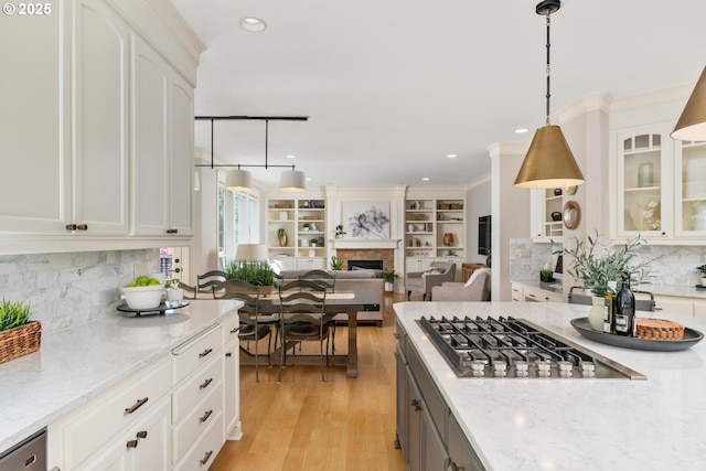 kitchen featuring stainless steel gas stovetop, glass insert cabinets, open floor plan, white cabinets, and recessed lighting