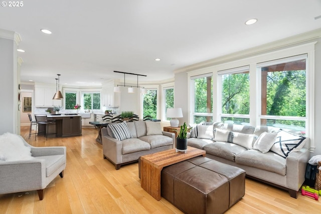 living room with recessed lighting, light wood-style floors, and crown molding