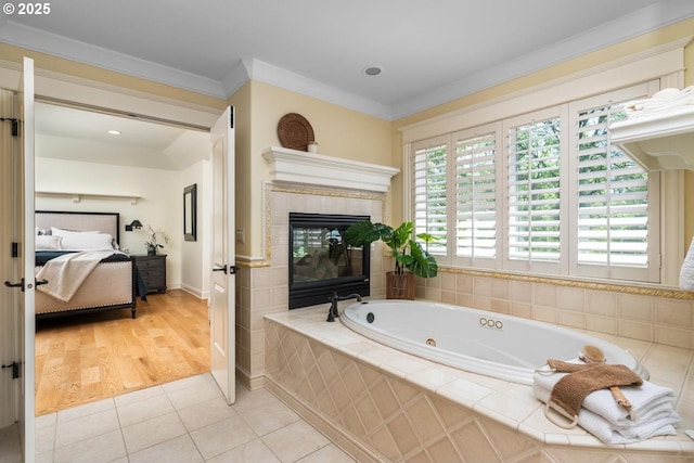 bathroom with ensuite bath, a tub with jets, a tile fireplace, tile patterned floors, and ornamental molding