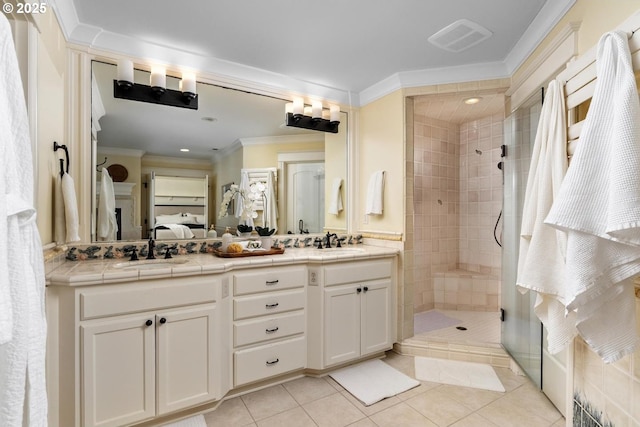 bathroom with a tile shower, double vanity, tile patterned floors, ensuite bath, and crown molding