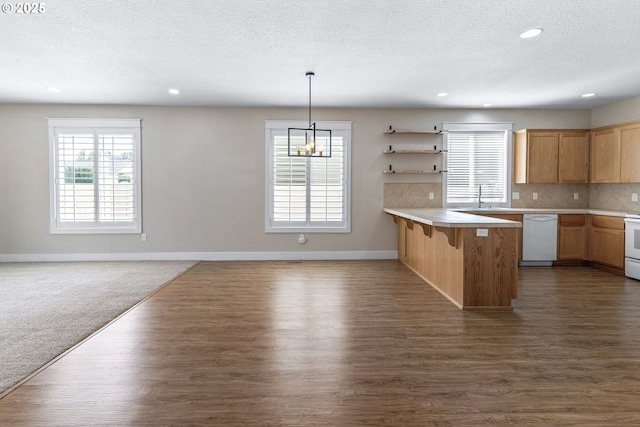 705 NW 25th Ave, Battle Ground, WA 98604 - kitchen featuring white dishwasher, a textured ceiling, a sink, a kitchen breakfast bar, and open floor plan