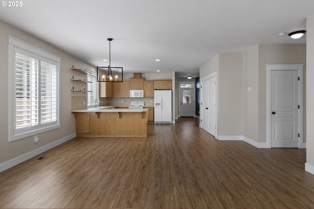 705 NW 25th Ave, Battle Ground, WA 98604 - kitchen featuring white appliances, baseboards, light countertops, dark wood-style floors, and a peninsula