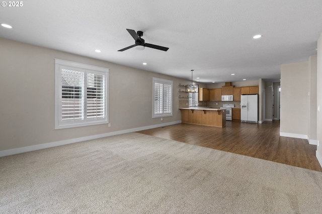 705 NW 25th Ave, Battle Ground, WA 98604 - unfurnished living room featuring dark carpet, a ceiling fan, baseboards, and recessed lighting